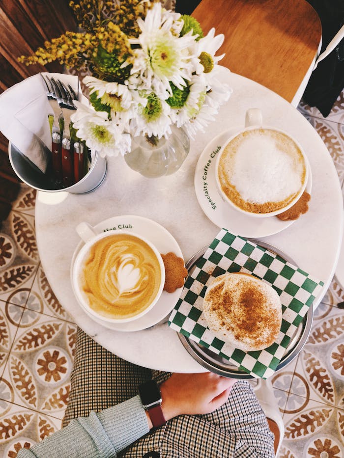 Cozy cafe scene featuring cappuccino, latte, and cinnamon roll on a stylish table in Ankara.